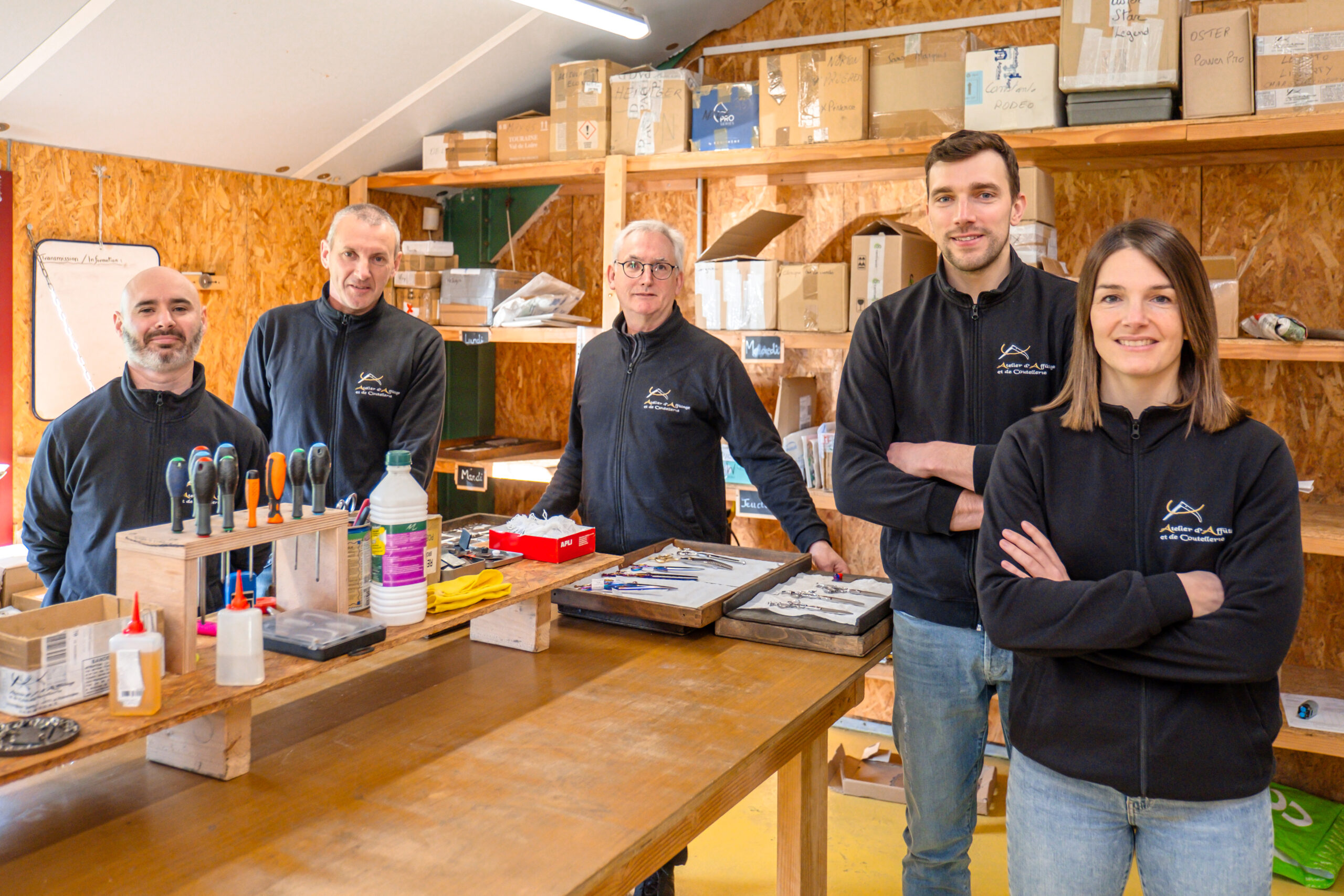 Équipe de L'Atelier d'affûtage dans leur espace de travail avec outils d'affûtage.