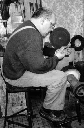 Robert Cartier affûtant un outil sur une machine à L'Atelier d'affûtage, après la fondation dans les années 90. 